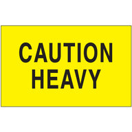 Fluorescent yellow caution heavy label with black text, rectangular