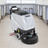 Walk-behind floor scrubber with gray housing, black head, and front wheels